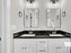 Bathroom featuring double sinks with black granite countertops and wall-mounted mirrors at 621 Ray St, Selma, NC 27576