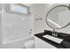 Bathroom featuring a round mirror above the sink and a bathtub-shower combination at 621 Ray St, Selma, NC 27576