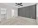 Bedroom with neutral carpet, accent wall, ceiling fan, and attached bathroom with walk-in closet at 621 Ray St, Selma, NC 27576