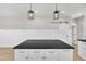 Kitchen island features black countertop, white cabinets with modern pulls, and pendant lighting above the bar at 621 Ray St, Selma, NC 27576