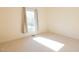 Empty bedroom with neutral carpet, white walls, and natural light from a large window at 627 Carraway Dr, Graham, NC 27253