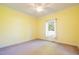 Carpeted bedroom offers a ceiling fan and single casement window at 627 Carraway Dr, Graham, NC 27253