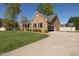 Charming brick house featuring a well-manicured lawn, long driveway, and attached garage at 627 Carraway Dr, Graham, NC 27253