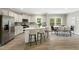 Bright kitchen with white cabinets, stainless steel appliances, a marble island with seating, and an adjacent dining area at 6312 Briddle Dr, Wendell, NC 27591