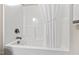 A bright white bathtub with shower, faucet, curtain, and safety stickers offers a clean aesthetic at 6819 Franklin Heights Rd, Cary, NC 27518