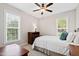 Cozy bedroom boasts natural light from two windows and comfy decor with a ceiling fan at 6819 Franklin Heights Rd, Cary, NC 27518