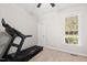 Bright room featuring a treadmill, a window letting in natural light, neutral walls, and carpet flooring at 6819 Franklin Heights Rd, Cary, NC 27518