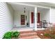 Inviting front porch with brick steps, decorative columns, and a charming seating area at 6819 Franklin Heights Rd, Cary, NC 27518