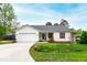 Charming single-story home featuring a well-manicured lawn, attached garage, and inviting front porch at 6819 Franklin Heights Rd, Cary, NC 27518