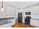 Bright kitchen with white cabinets, stainless steel appliances, and hardwood floors, leading to the laundry area at 6819 Franklin Heights Rd, Cary, NC 27518