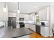 Bright kitchen showcasing white cabinetry, stainless steel appliances, dark countertops, and natural light from the window at 6819 Franklin Heights Rd, Cary, NC 27518