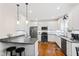 Modern kitchen featuring white cabinetry, stainless steel appliances, a breakfast bar, and hardwood floors at 6819 Franklin Heights Rd, Cary, NC 27518