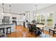 Modern kitchen with white cabinets, stainless steel appliances, and an adjacent dining area at 6819 Franklin Heights Rd, Cary, NC 27518
