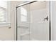 Modern white shower with glass door, window and bronze hardware offers natural light at 6819 Franklin Heights Rd, Cary, NC 27518