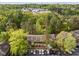 An aerial view showcases the property among a lush green tree canopy and nearby city at 708 Martin Luther King Jr. Blvd # E2, Chapel Hill, NC 27514