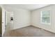 Bedroom features neutral walls, plush carpeting, and an open doorway to a kitchen area at 7120 Guess Rd, Hillsborough, NC 27278
