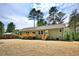 Backyard view of home with wooden deck, newly seeded yard and wooded backdrop at 7120 Guess Rd, Hillsborough, NC 27278