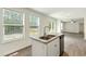 Kitchen island with a stainless steel sink, a double window and a view of the deck at 7120 Guess Rd, Hillsborough, NC 27278