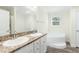 Bright bathroom featuring double sinks, a wide mirror, plus a large soaking tub and window at 7122 Guess Rd, Hillsborough, NC 27278