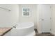 A corner soaking tub sits next to a window, providing natural light in this bathroom at 7122 Guess Rd, Hillsborough, NC 27278