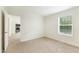 This carpeted bedroom features a large window and a door to the hallway at 7122 Guess Rd, Hillsborough, NC 27278