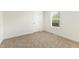 This bedroom features neutral carpet, a large window, and a door to the hallway at 7122 Guess Rd, Hillsborough, NC 27278