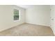 This cozy carpeted bedroom features one large window and a door to the hallway at 7122 Guess Rd, Hillsborough, NC 27278