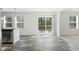 Bright dining area with wood-look flooring, a sliding glass door to the deck, and two windows at 7122 Guess Rd, Hillsborough, NC 27278