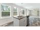 Kitchen island with sink and stainless steel dishwasher next to windows with backyard view at 7122 Guess Rd, Hillsborough, NC 27278