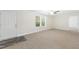 Unfurnished living room with neutral carpeting, white walls, and a large window for natural light at 7122 Guess Rd, Hillsborough, NC 27278