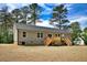 Rear view of home featuring a wooden deck, gray siding, and stone foundation at 7122 Guess Rd, Hillsborough, NC 27278