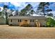 Rear view of home featuring a wooden deck, gray siding, and stone foundation at 7122 Guess Rd, Hillsborough, NC 27278