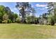 Expansive backyard featuring mature trees, lush lawn, and storage shed at 721 Shelley Rd, Raleigh, NC 27609