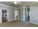 Well-lit bedroom with views into other rooms, carpet, and a fan at 721 Shelley Rd, Raleigh, NC 27609