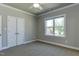 Neutral bedroom showcasing a window with a view, double closets, and carpet at 721 Shelley Rd, Raleigh, NC 27609