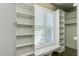 Walk-in closet featuring window with natural light and custom built-in shelving at 721 Shelley Rd, Raleigh, NC 27609