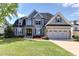 Charming two-story home with a well-manicured lawn, stone accents, and an attached two-car garage at 721 Shelley Rd, Raleigh, NC 27609