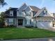 Charming two-story home with gray shingles, stone accents, a well-manicured lawn, and an attached two-car garage at 721 Shelley Rd, Raleigh, NC 27609