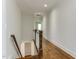 Hallway with hardwood floors and a staircase leading to the lower level of the home at 721 Shelley Rd, Raleigh, NC 27609