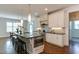 Modern kitchen island with barstool seating, stainless steel appliances, and pendant lighting at 721 Shelley Rd, Raleigh, NC 27609