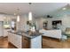 Open-concept kitchen island flows into a sunlit living room, perfect for modern living and entertaining at 721 Shelley Rd, Raleigh, NC 27609