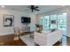 Modern living room with a white sofa, hardwood floors, stylish decor, and a TV at 721 Shelley Rd, Raleigh, NC 27609