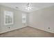 Bedroom boasting natural light with two windows, neutral carpet, and a ceiling fan for added comfort at 803 Driftwood Dr, Gibsonville, NC 27249