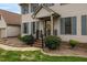 Close-up of the front porch with manicured bushes, brick steps and blue shutters at 803 Driftwood Dr, Gibsonville, NC 27249