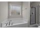 Bathroom featuring a soaking tub and glass shower, offering a relaxing retreat at 810 Mulberry Rd, Spring Hope, NC 27882