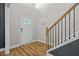 Bright foyer featuring hardwood floors, a white front door with stained glass, and a staircase at 810 Mulberry Rd, Spring Hope, NC 27882