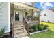 Inviting front porch with stone stairs, wood railings, and charming decorative plants at 810 Mulberry Rd, Spring Hope, NC 27882