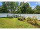 Backyard vegetable garden with raised beds and lush greenery along a white privacy fence at 810 Mulberry Rd, Spring Hope, NC 27882
