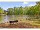 Idyllic view of the lake featuring a bench, surrounded by lush greenery and a clear blue sky at 900 Ambergate Sta, Apex, NC 27502