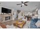 Open-concept living space flows to kitchen and dining area, featuring a stone fireplace and modern decor at 900 Ambergate Sta, Apex, NC 27502